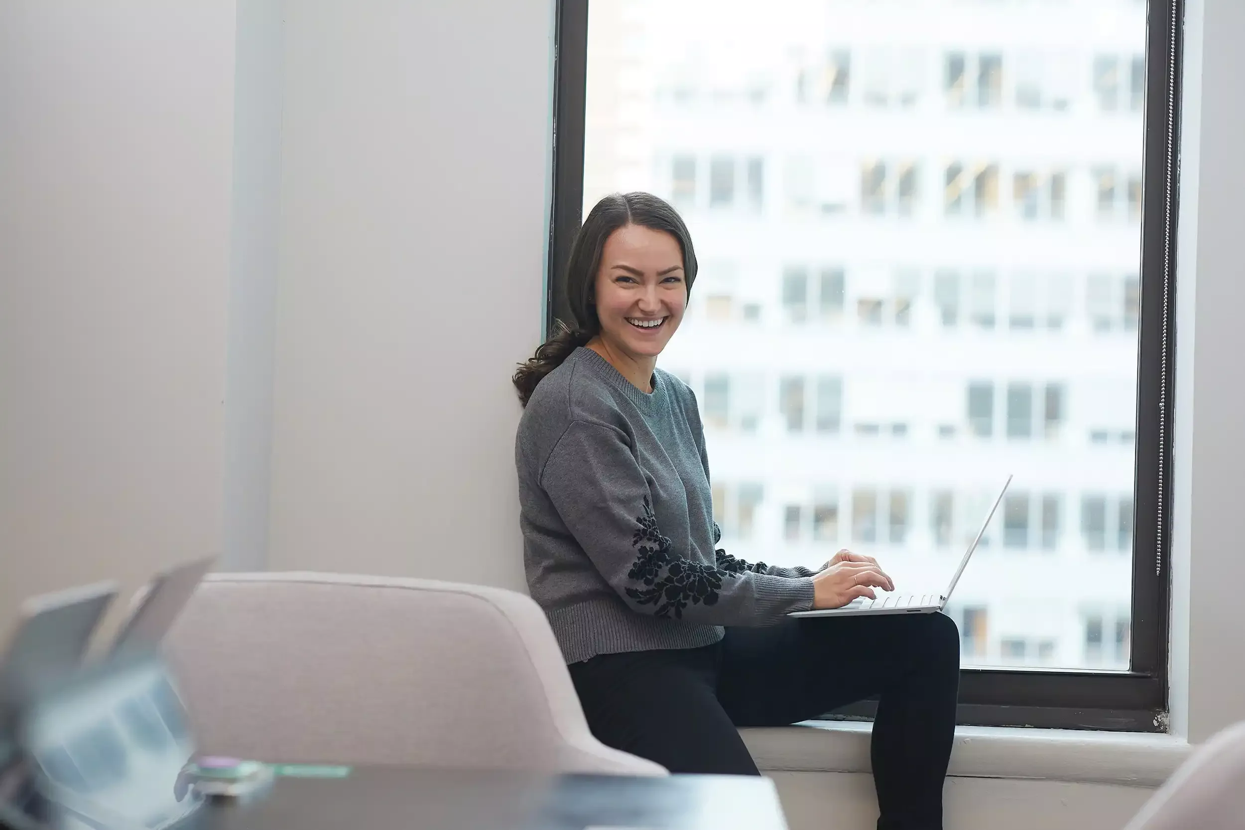 a woman smiling while using her notebook