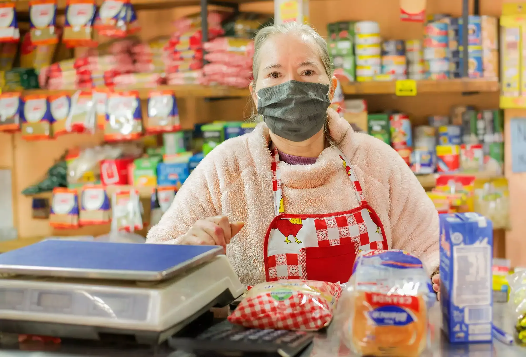 Imagem de uma senhora pesando alimentos